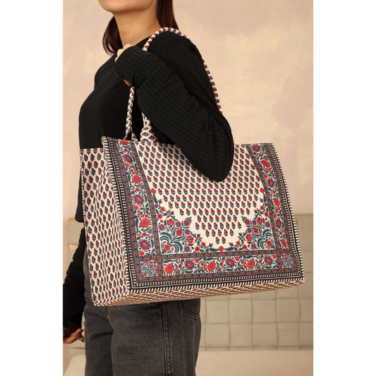 Woman carrying Bagwati Chatai canvas tote bag in red and white with floral pattern