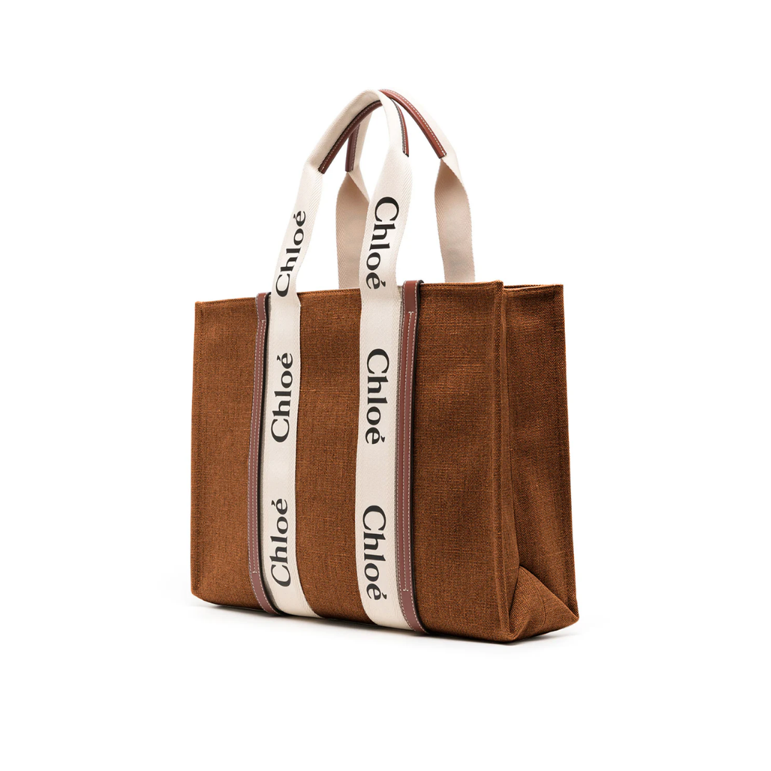 Dark brown canvas tote bag with white Chloé logo handles, elegant and spacious design