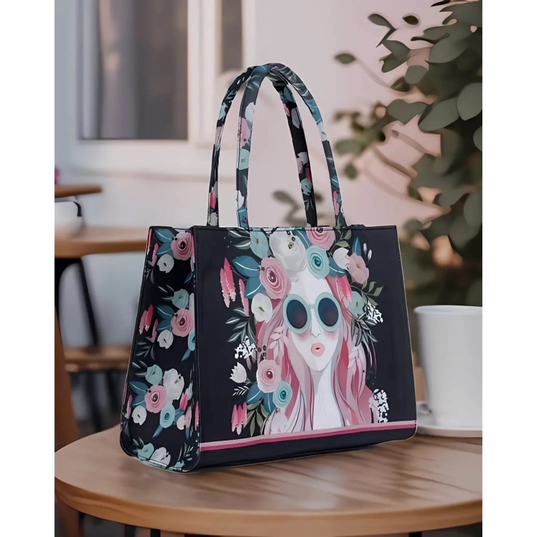 Bagwati black canvas tote bag with colorful floral woman graphic, displayed on table
