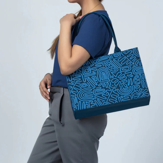 Woman carrying Bagwati blue canvas tote bag with abstract doodle art print