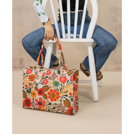 Bagwati multicolor floral canvas tote bag resting by a chair, casual fashion accessory