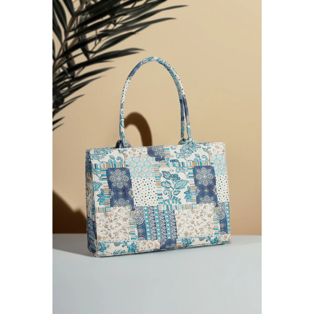 Bagwati blue patchwork canvas handbag with floral and geometric patterns, tabletop display