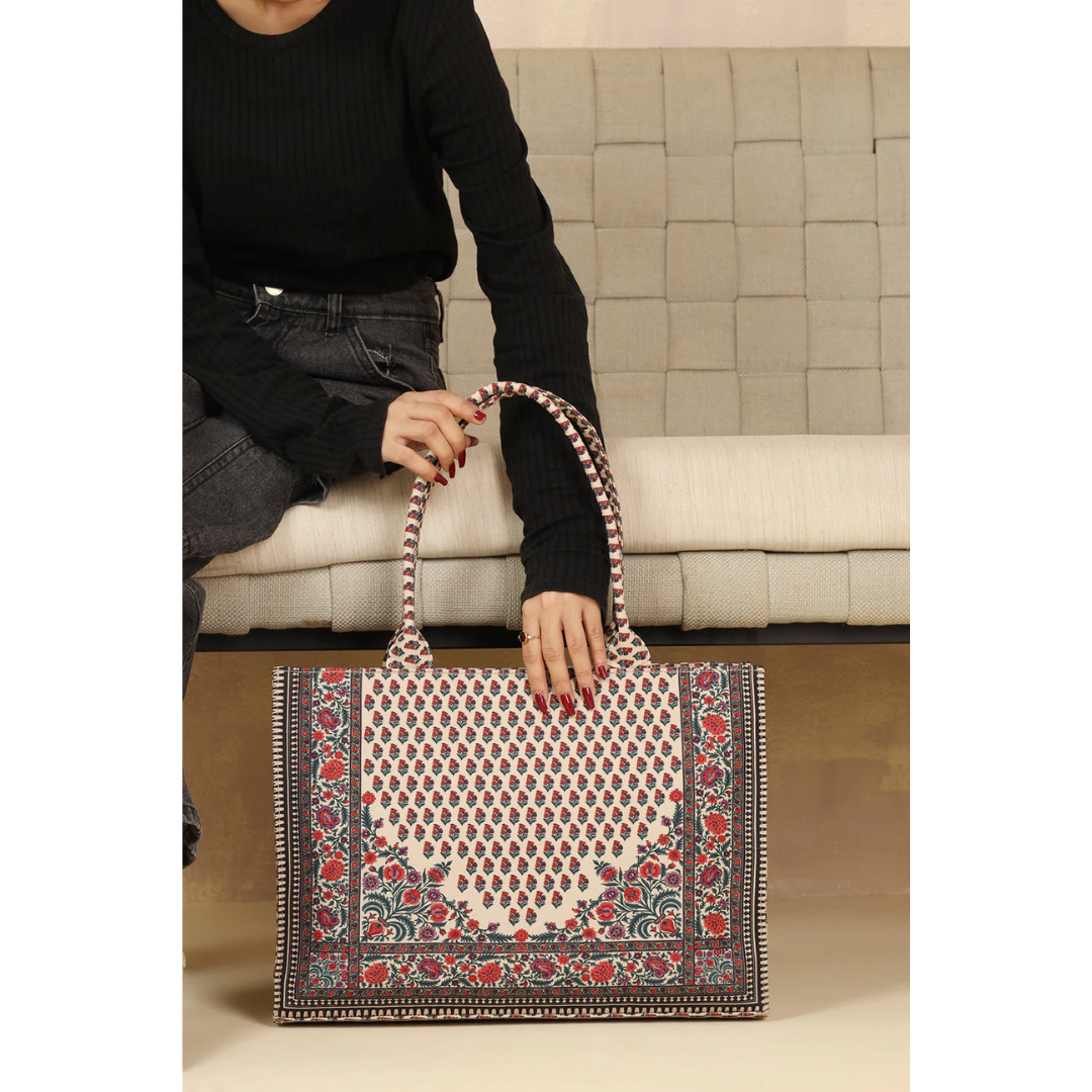 Bagwati red and white Chatai canvas tote bag with floral print, displayed on a sofa