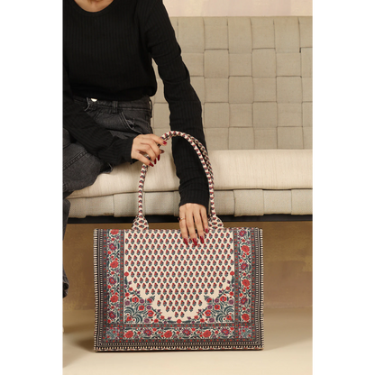 Bagwati red and white Chatai canvas tote bag with floral print, displayed on a sofa