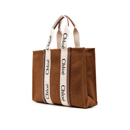 Dark brown canvas tote bag with white Chloé logo handles, elegant and spacious design