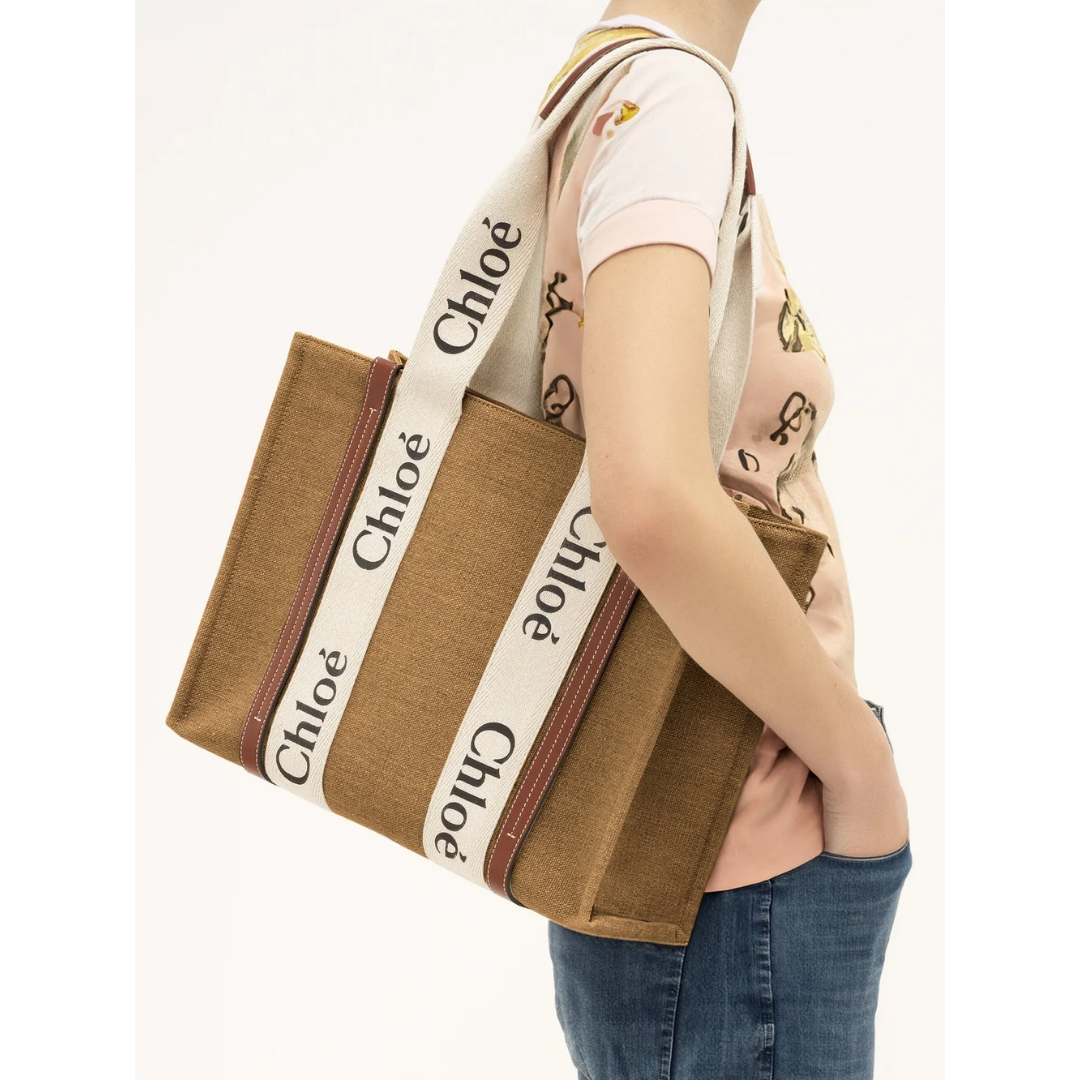 Light brown canvas tote bag with white Chloé logo straps, carried on shoulder