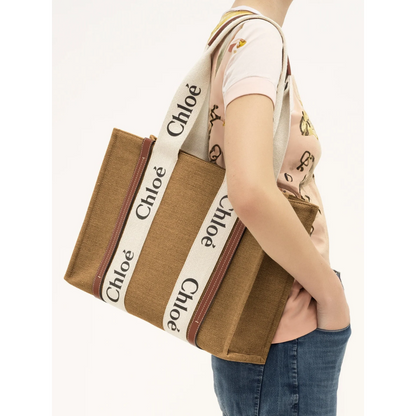 Light brown canvas tote bag with white Chloé logo straps, carried on shoulder