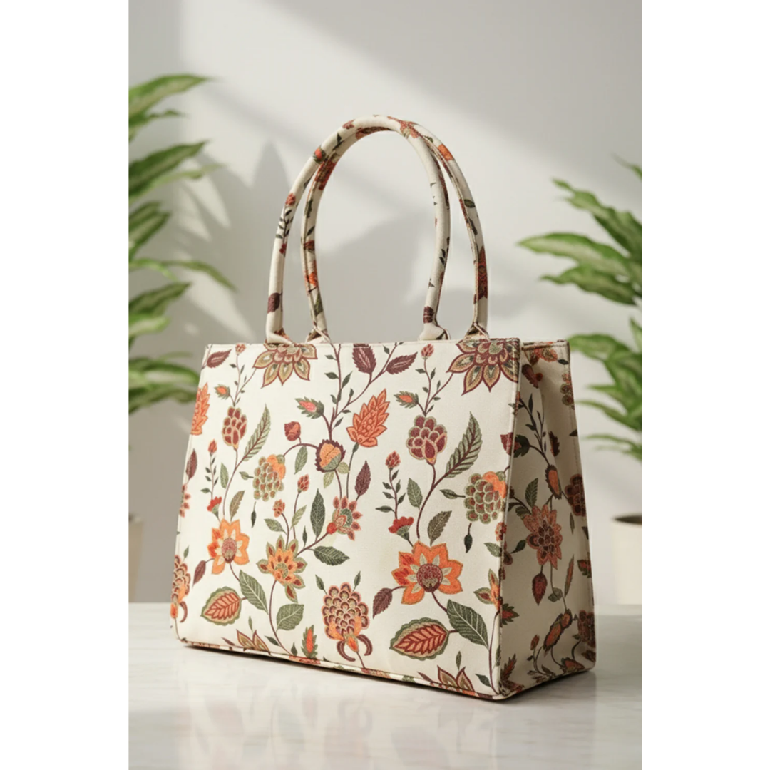 Bagwati beige floral canvas tote bag on white surface with green plants in background