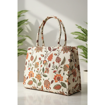 Bagwati beige floral canvas tote bag on white surface with green plants in background
