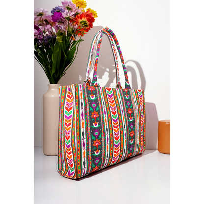 Colorful floral patterned canvas tote bag by Bagwati, displayed beside a vase of flowers.
