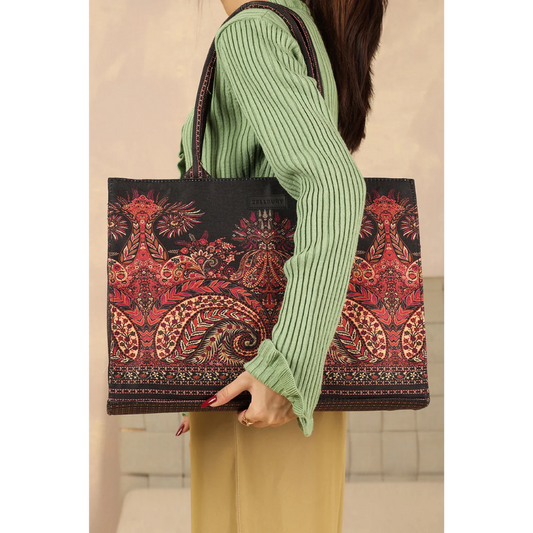 Woman holding Bagwati Mughal Muse red pattern tote bag with intricate ethnic design