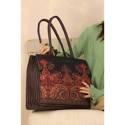 Bagwati Mughal Muse red patterned canvas tote bag with double handles, held by a woman