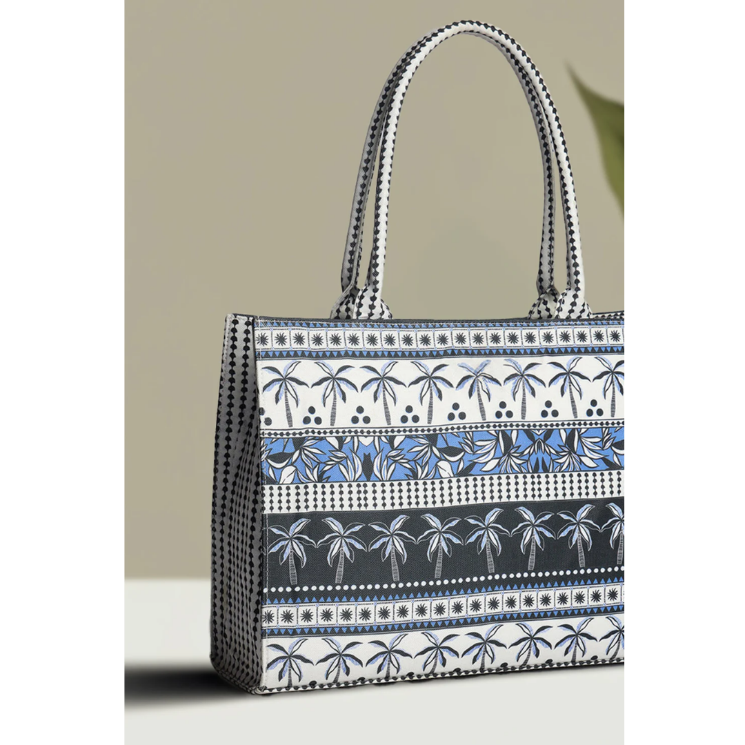 Bagwati canvas tote bag with blue palm tree pattern and dual handles on neutral background