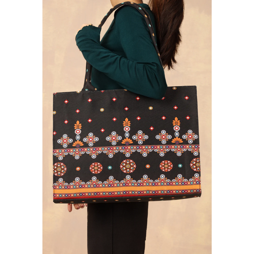 Bagwati black traditional canvas tote bag with colorful ethnic patterns, carried on shoulder